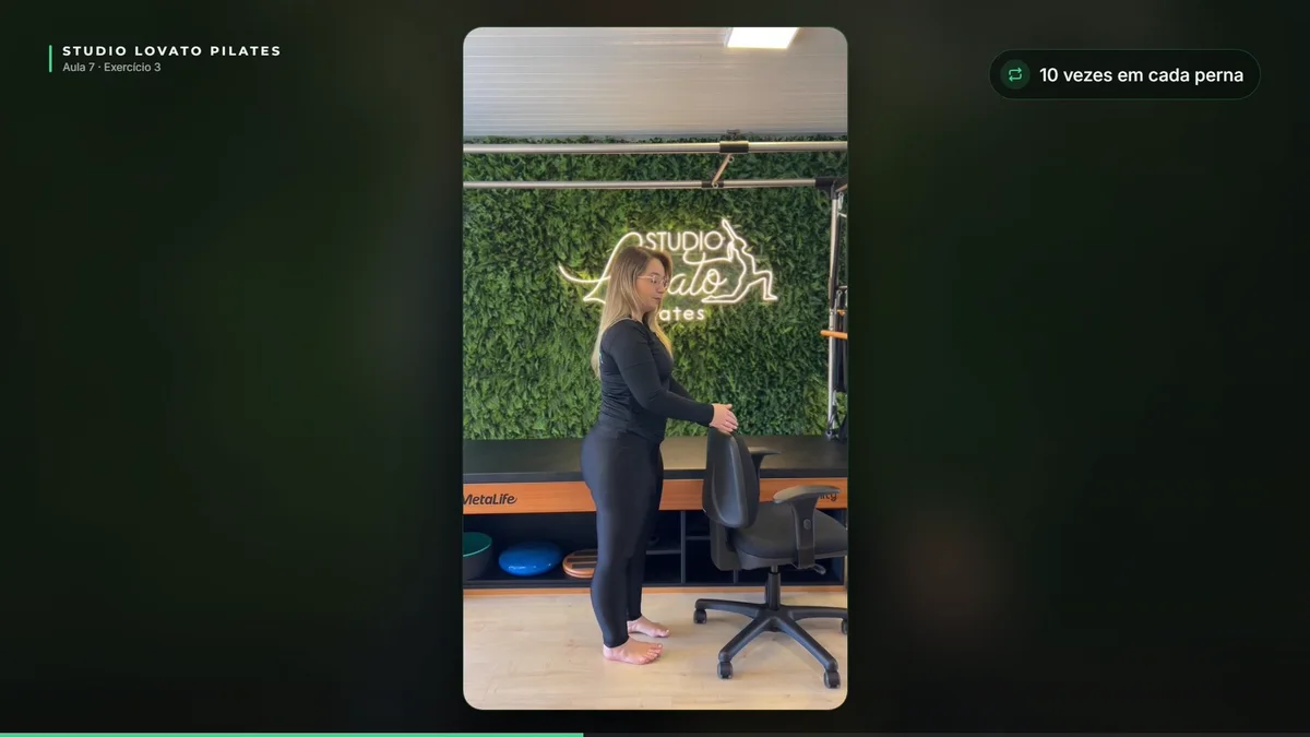 Frame da Aula 7: o exercício “Perna estendida para trás” demonstrado numa cadeira de escritório, a versão para fazer sentada no meio do dia.